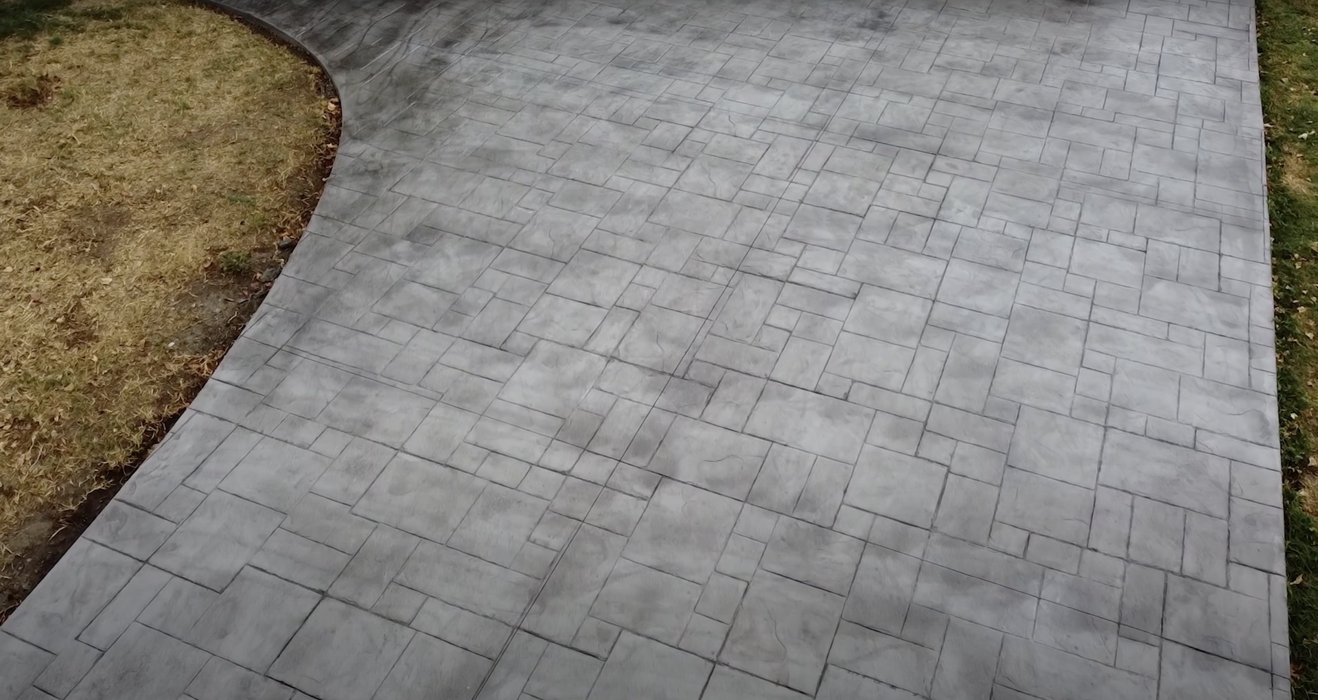 Beautiful stamped concrete patio with herringbone pattern showing professional installation