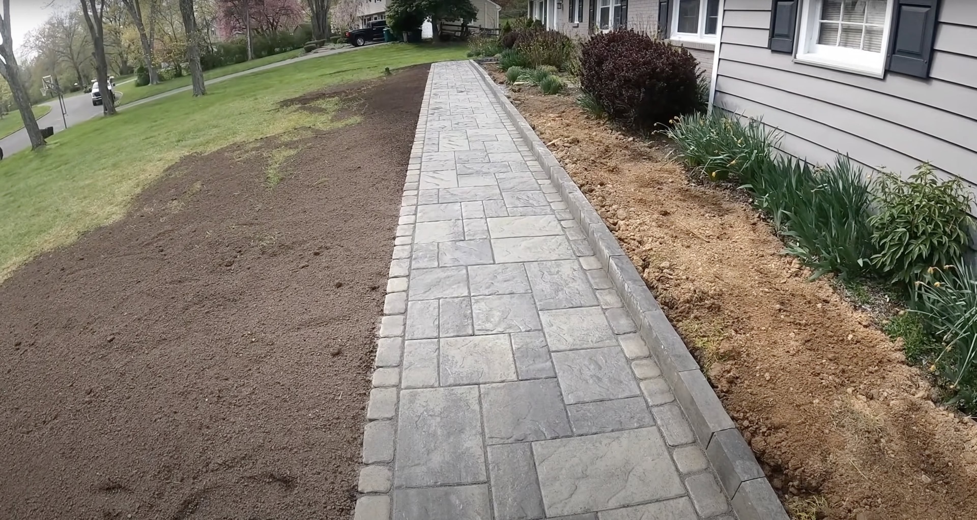 Stamped concrete walkway with natural stone pattern leading to residential entrance